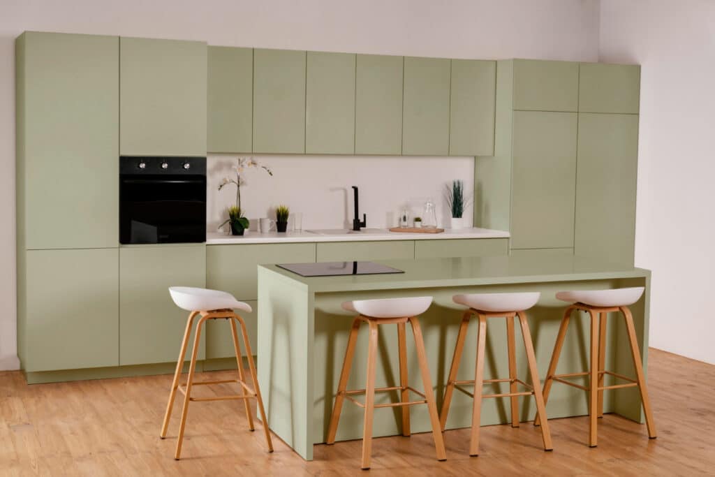 Een website met keukenportfolio waarin foto's van keukens zoals deze groene designkeuken te zien zijn, is essentieel voor keukenwinkels